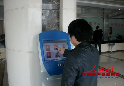 （图为前来办事的群众对窗口工作人员服务质量进行评价）